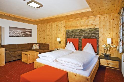 费尔兹姆斯费尔兹姆斯阿尔蓬霍夫兰德酒店的一间卧室配有一张大床和一张沙发