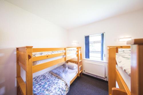 巴林托伊White Park Bay Youth Hostel的一间卧室设有两张双层床和一扇窗户。