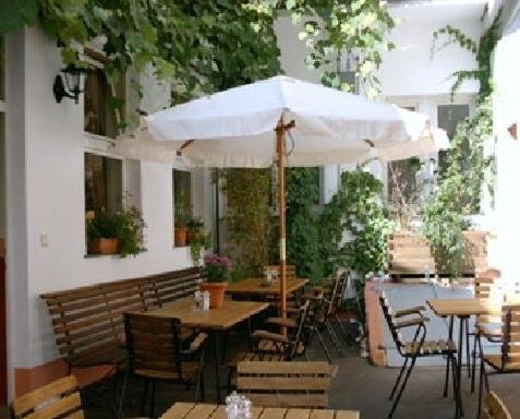 特里尔弗兰肯图尔姆餐厅酒店的一个带桌椅和遮阳伞的庭院