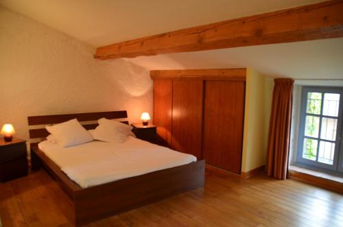 Auriac-sur-Vendinelle奥坦玫瑰度假屋的一间卧室配有一张带白色床单的床和一扇窗户。