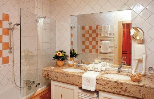 科尔马Hotel Saint-Martin的一间带两个盥洗盆和大镜子的浴室