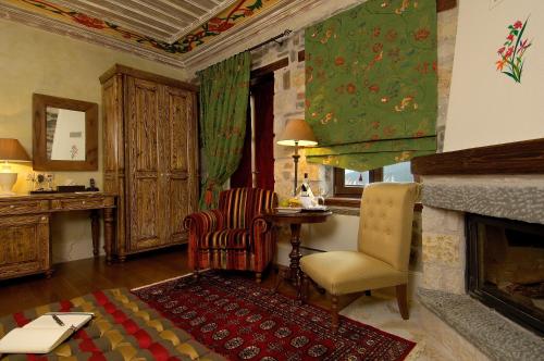 Voútiron情调乡村度假酒店的客厅设有壁炉、桌子和椅子