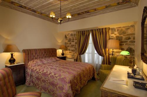 Voútiron情调乡村度假酒店的酒店客房带一张床、一张桌子和椅子