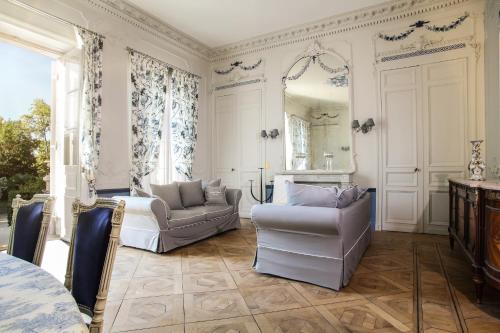 Notre-Dame-de-SanilhacChambres d'hotes de Pouzelande的客厅配有两把椅子和镜子