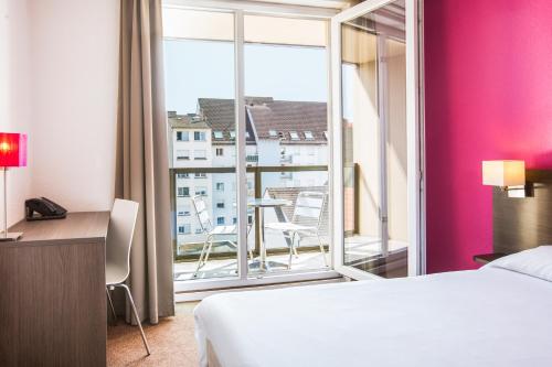 斯特拉斯堡斯塔拉斯堡小法国阿德吉奥阿克瑟斯公寓式酒店的酒店客房设有一张床和一个大窗户
