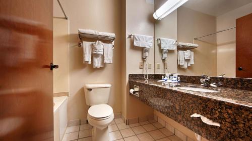 爱德蒙SureStay Plus by Best Western Edmond的一间带卫生间、水槽和镜子的浴室