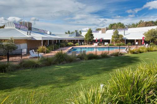 堪培拉堪培拉雄鹰宜必思尚品酒店的一座带游泳池和庭院的房子