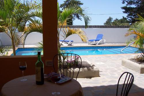洛斯·亚诺斯·德·阿里丹Apartamentos Villa María的一张桌子,旁边是一瓶葡萄酒和两把椅子