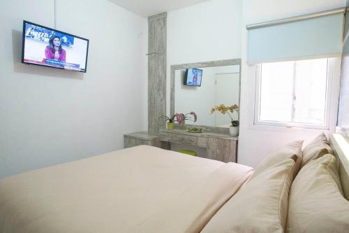 当格浪航空城德格林酒店的卧室配有一张床,墙上配有电视。