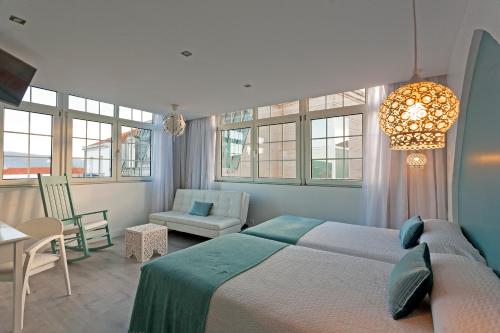 维戈Hotel Alda Puerta Del Sol的一间卧室配有一张床、一把椅子和窗户。