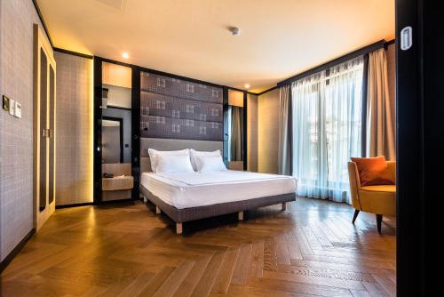 索非亚Eurostars Sofia City的一间卧室,卧室内配有一张床和一把椅子