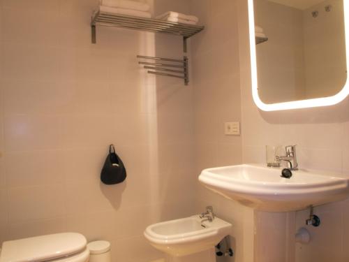 厄尔梅达诺Apartmento La Perla el Medano的一间带水槽、卫生间和镜子的浴室