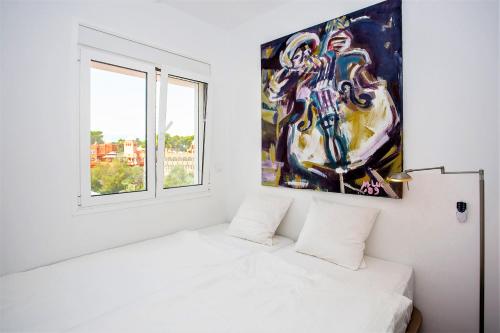 马贝拉Luxury Apartments with private swimming pool的白色卧室,墙上挂有绘画作品