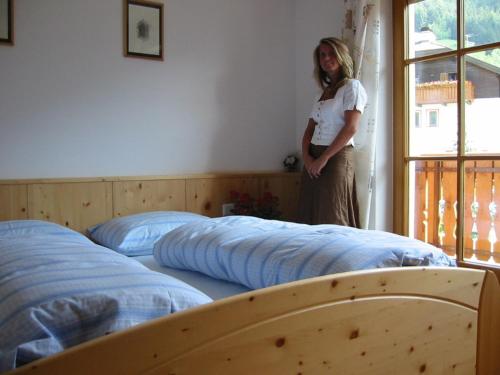 拉伊翁Nature Residence Telfnerhof的一位妇女站在带两张床的房间