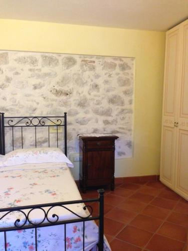 GalloB&B La Casa Vecchia的一间卧室设有一张床和石墙