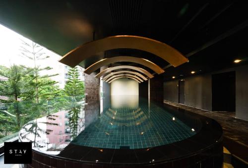 曼谷STAY Hotel BKK - SHA PLUS的一座带天花板的建筑中的游泳池