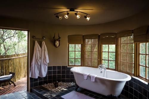 莫迪默勒Monate Game Lodge的带浴缸的浴室,带窗户