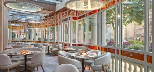 伦敦梅宝尼康诺酒店的餐厅设有桌椅和大窗户。