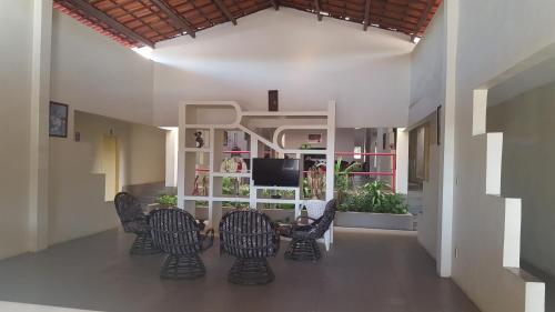 北茹阿泽鲁Pousada Portal do Cariri的客厅配有椅子、桌子和电视