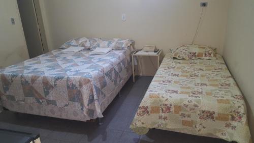 北茹阿泽鲁Pousada Portal do Cariri的一间卧室配有两张床和一部电话