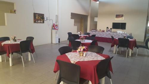 北茹阿泽鲁Pousada Portal do Cariri的一间带桌椅和红色桌布的用餐室