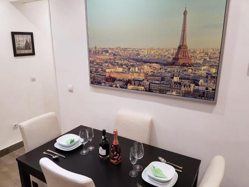 马德里介子德帕雷德斯公寓的用餐室配有带酒杯的桌子和艾菲尔铁塔