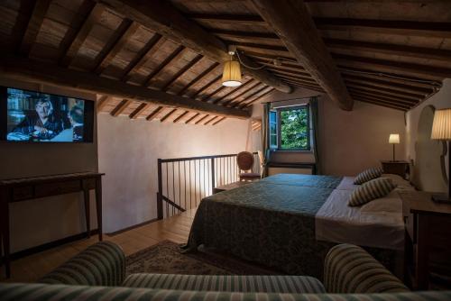 Montecalvo in FogliaCa' Virginia Country House Wellness的一间卧室配有一张床和一台平面电视