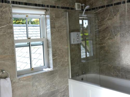 SkullRivers Bend Cottage的带淋浴和浴缸的浴室以及窗户。