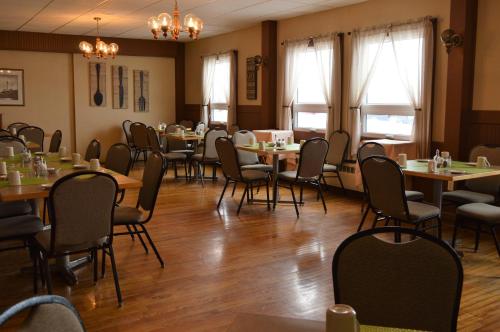 钱纳尔-巴斯克港巴斯克港口酒店的用餐室设有桌椅和窗户。
