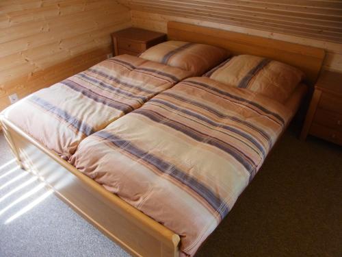 科沃布热格Ferienhaus Franziska的木墙客房的一张未铺好的床