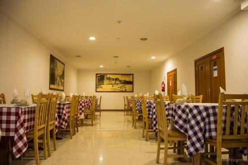 SearaHotel Pinheiro Manso的餐厅内带桌椅的用餐室