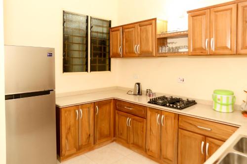阿克拉Connect Africa Apartments的厨房配有木制橱柜和不锈钢冰箱。