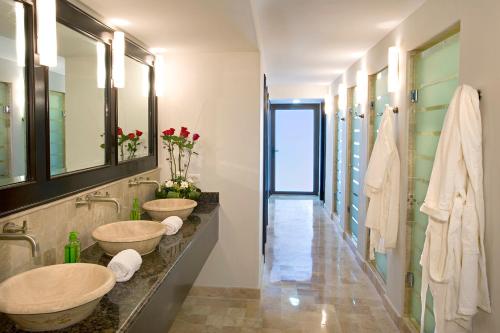 马萨特兰Las Villas Hotel & Golf By Estrella del Mar的一间带两个盥洗盆和走廊的浴室