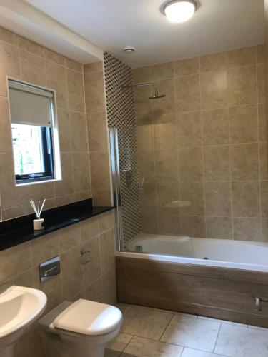 卡文Holiday Home On Farnham Estate的带浴缸、卫生间和盥洗盆的浴室