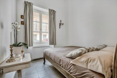 凡尔赛凡尔赛小亭子公寓的一间卧室设有一张床、一个窗口和一张桌子