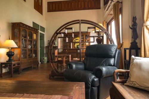 曼谷工匠的古董屋 - 席隆的客厅配有真皮沙发和椅子