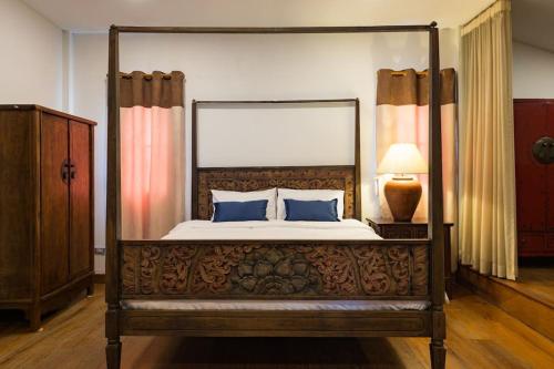 曼谷工匠的古董屋 - 席隆的一间卧室配有一张带蓝色枕头的天蓬床