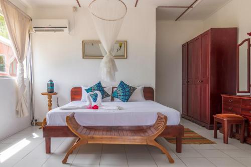 博瓦隆香茅旅馆的一间卧室配有一张床和长凳