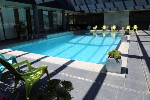比居格利亚库尔斯酒店的一个带绿色椅子和椅子的游泳池