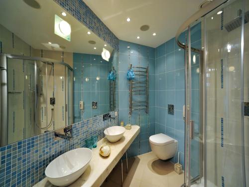 尤尔马拉Boutique Hotel Light House Jurmala的蓝色瓷砖浴室设有2个水槽和淋浴