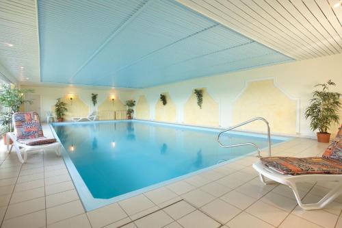 肖顿AKZENT Hotel Haus Sonnenberg的一个带椅子的房间的大型游泳池