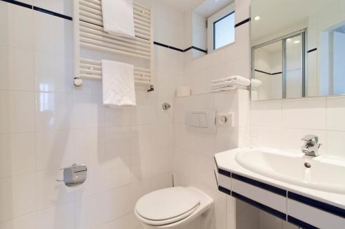 布隆Hotel Seeblick Garni的白色的浴室设有卫生间和水槽。