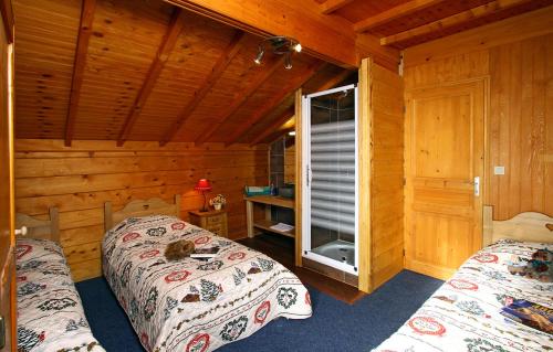 莱德萨阿尔卑斯Odalys Chalet Le Ponton的小木屋内一间卧室,配有两张床