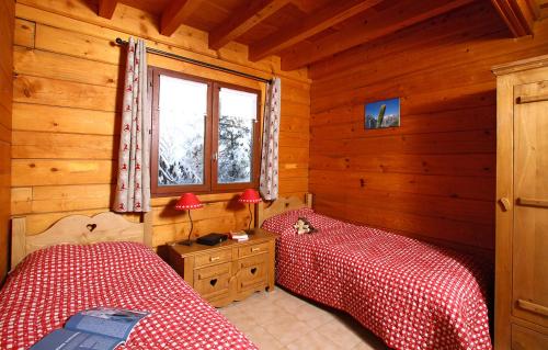 莱德萨阿尔卑斯Odalys Chalet Le Ponton的小木屋内一间卧室,配有两张床