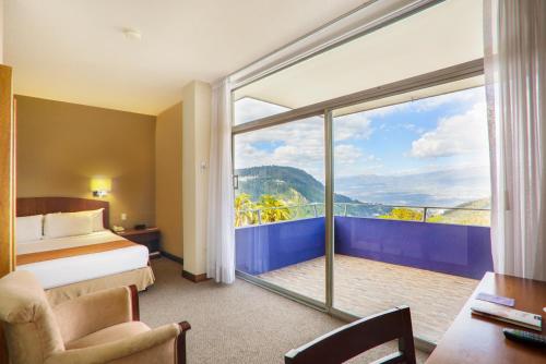 基多Hotel Quito的酒店客房设有一张床和一个大窗户