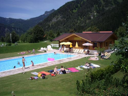埃普芬多夫Gut Hanneshof的一群人躺在游泳池边的草地上