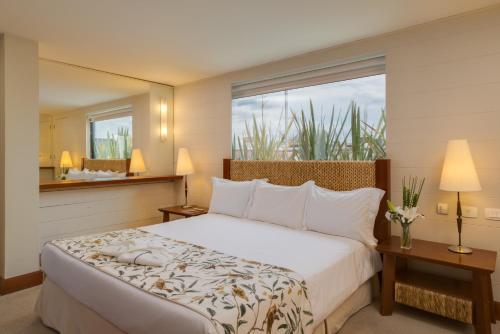 南卡希亚斯蓝树塔南卡希亚斯酒店的一间卧室设有一张大床和一个大窗户