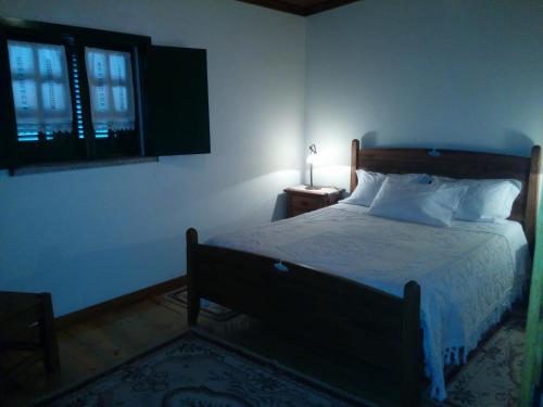 索茹Casa Do Grilo Soajo的一间卧室设有床、窗户和一盏灯。
