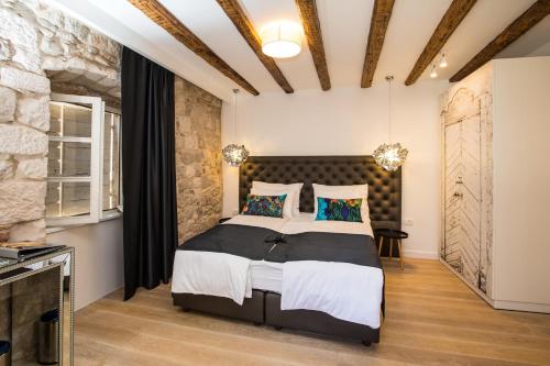 斯普利特斯帕拉多奢华客房住宿加早餐旅馆的一间卧室设有一张大床和石墙