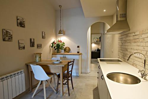 奥洛特El Jardinet de Sant Esteve的厨房配有水槽和桌椅